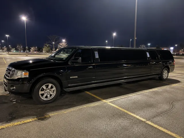 Black Ford Excursion stretch limo at night