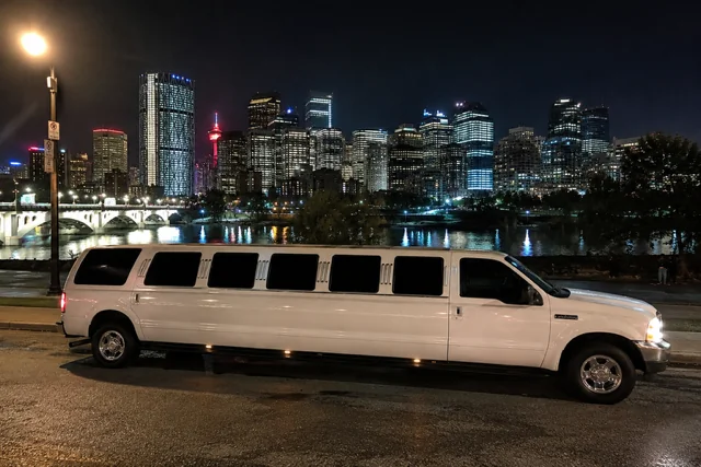 White stretch limo with Calgary skyline at night — Calgary Stampede Limo
